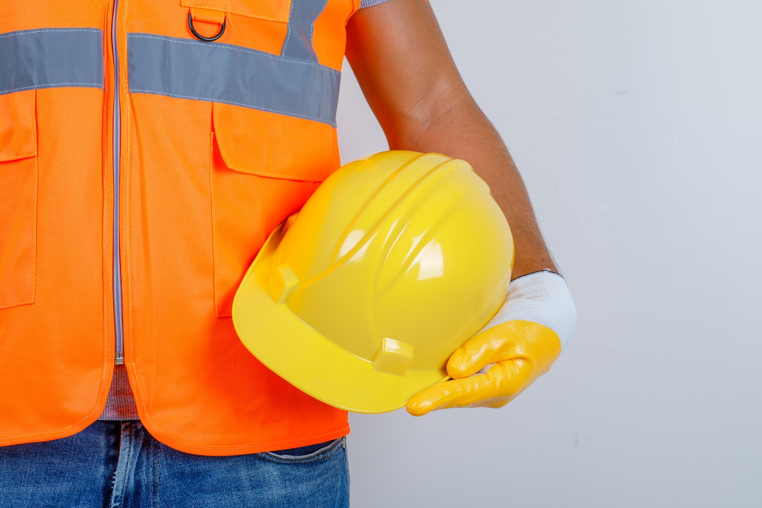 male-builder-in-uniform-jeans-gloves-holding-helmet-in-his-hand-front-view.jpg